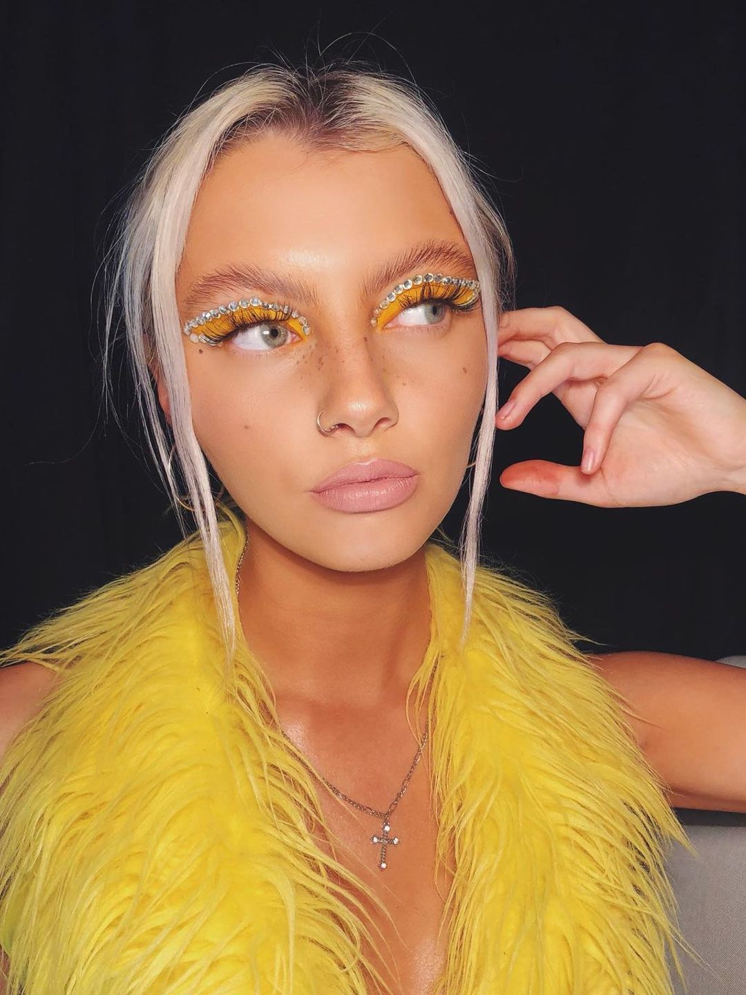 Girl wearing yellow eyeshadow and gems 