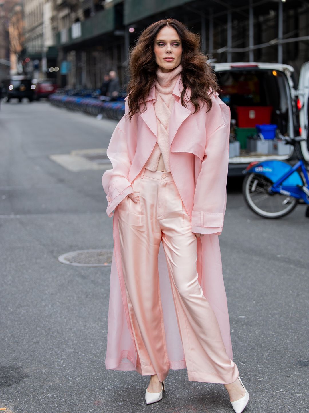 Coco Rocha wears pink pants, coat, turtleneck outside Lapointe