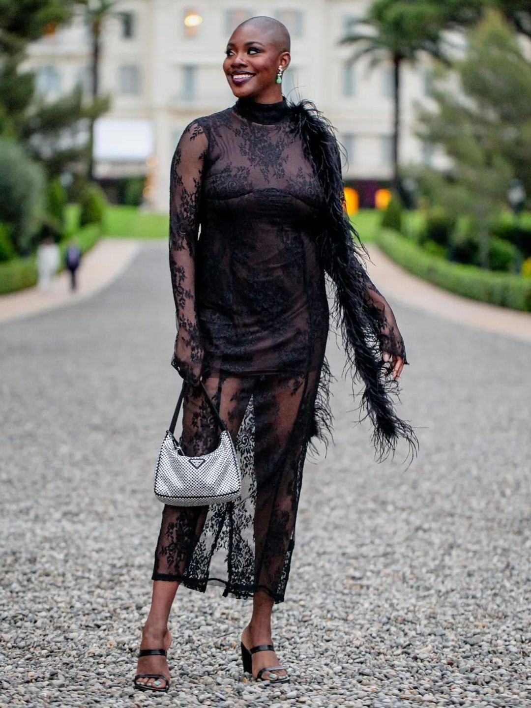 Yomi wears a black lace dress and a Prada bag