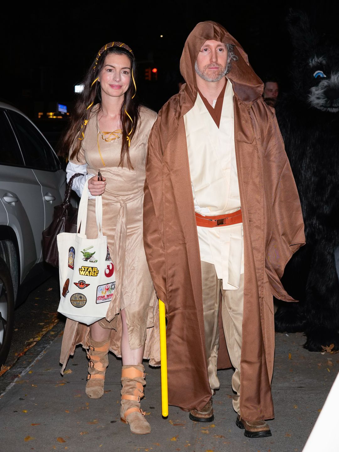 Anne Hathaway and Adam Shulman walk New York City streets dressed as "Star Wars" characters. Anne, as Princess Leia, wears a medieval-style beige dress, while Adam channels Jedi Luke Skywalker in a brown robe.