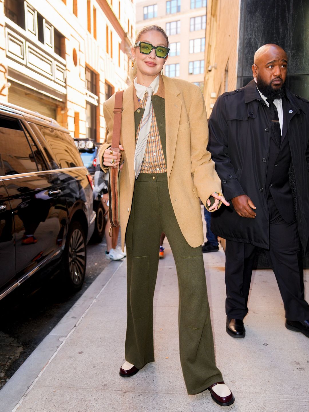 Gigi Hadid out and about on October 14, 2022 in New York City wearing a green suit and camel toned blazer 