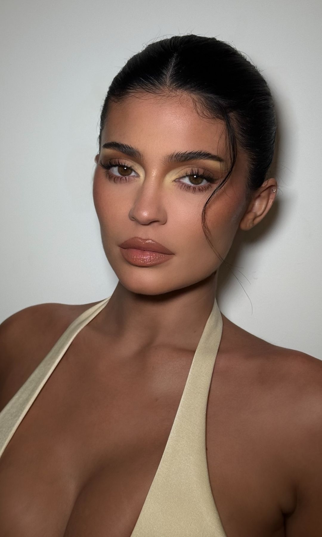 Kylie Jenner poses in a yellow makeup look