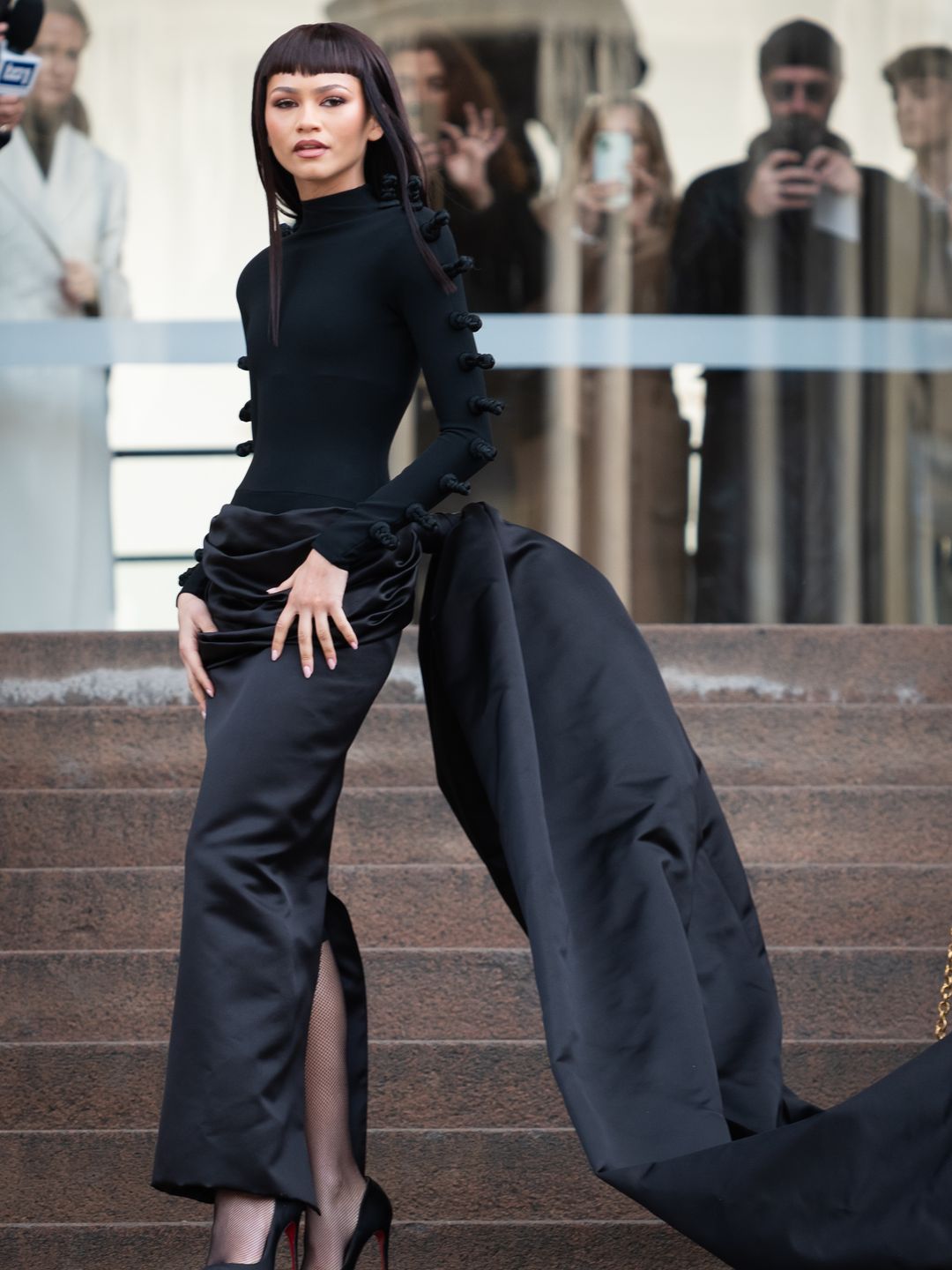 Zendaya wearing a black top and skirt by Schiaparelli and fishnet socks 