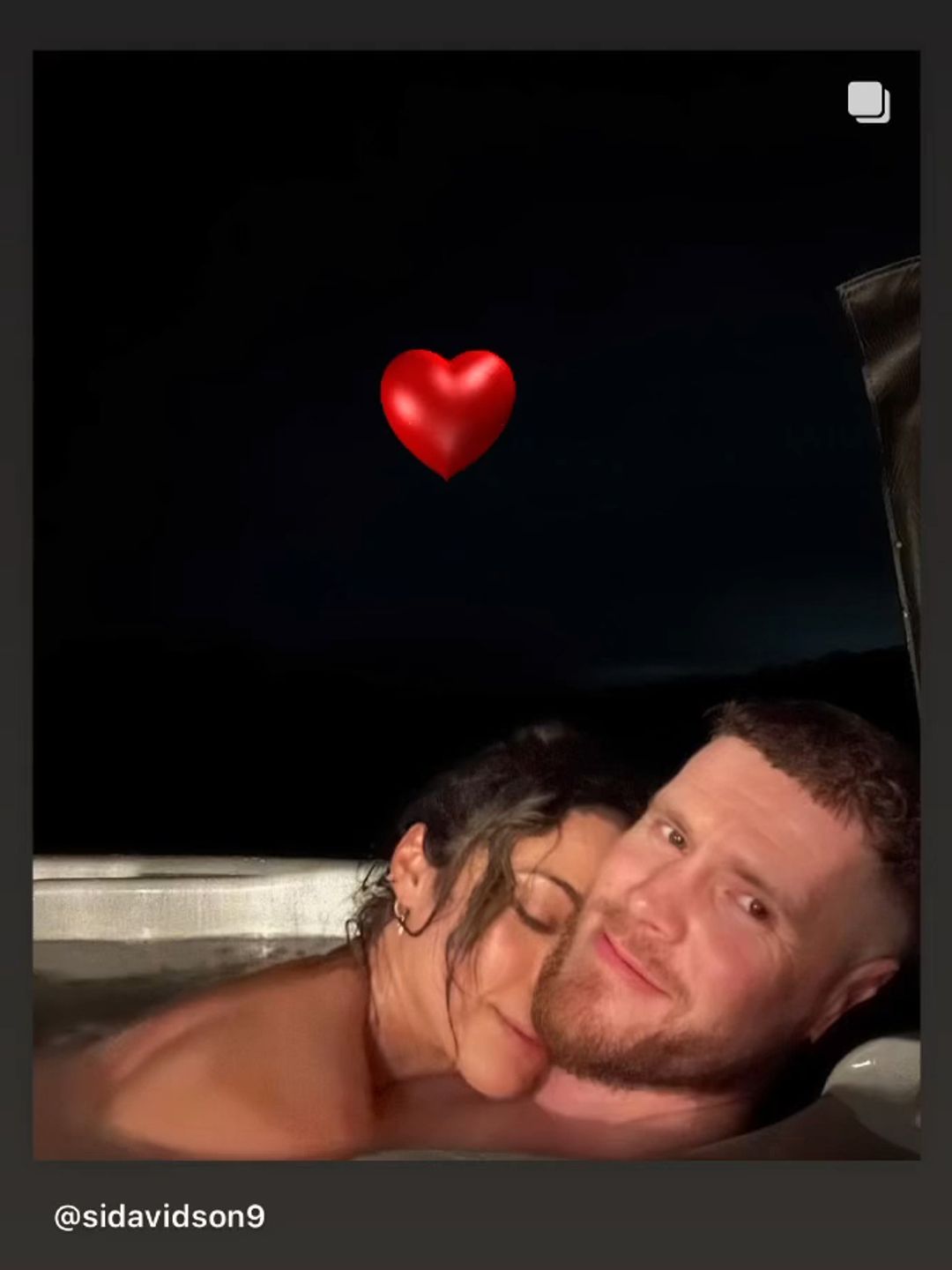 Karen Hauer hugging her partner Simon in the hot tub at night