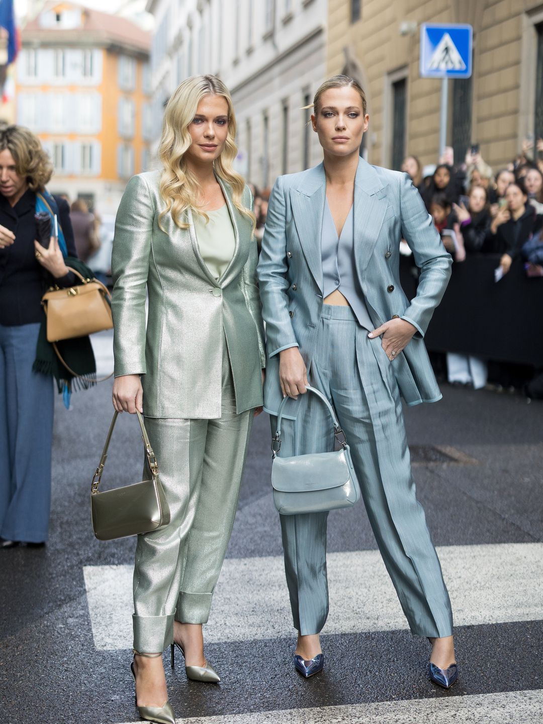sisters posing in metallic suits on zebra crossing
