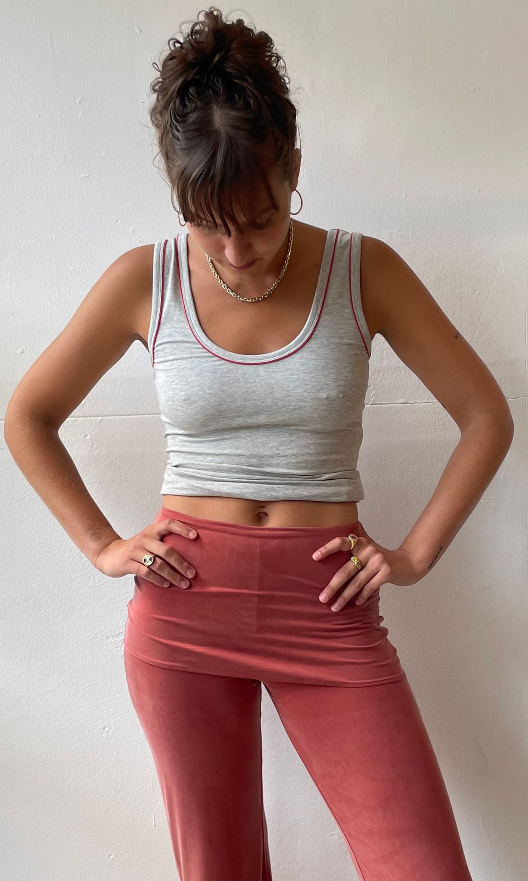 rosie viva in red trousers and grey tank top