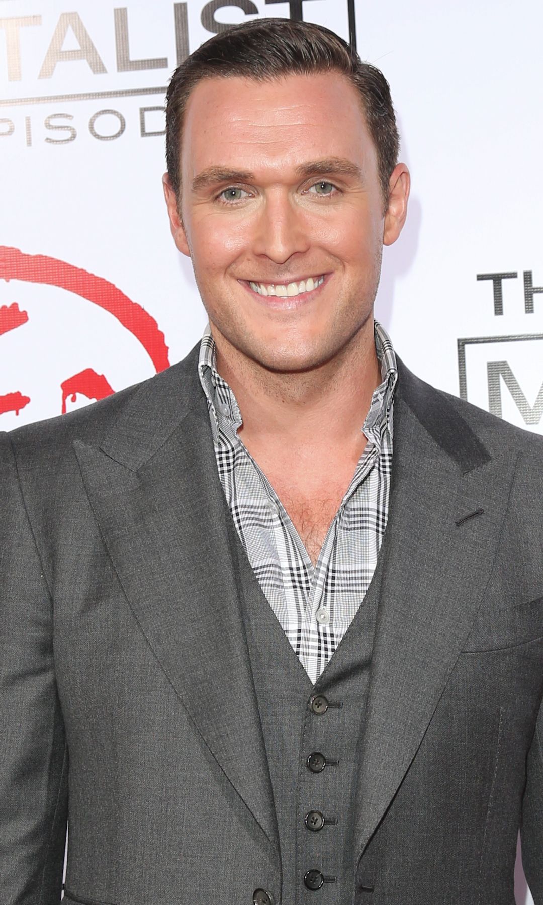 Owain Yeoman in a grey suit at a premiere for The Mentalist