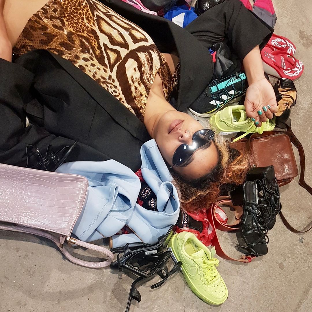 Woman lying on the floor surrounded by clothes 