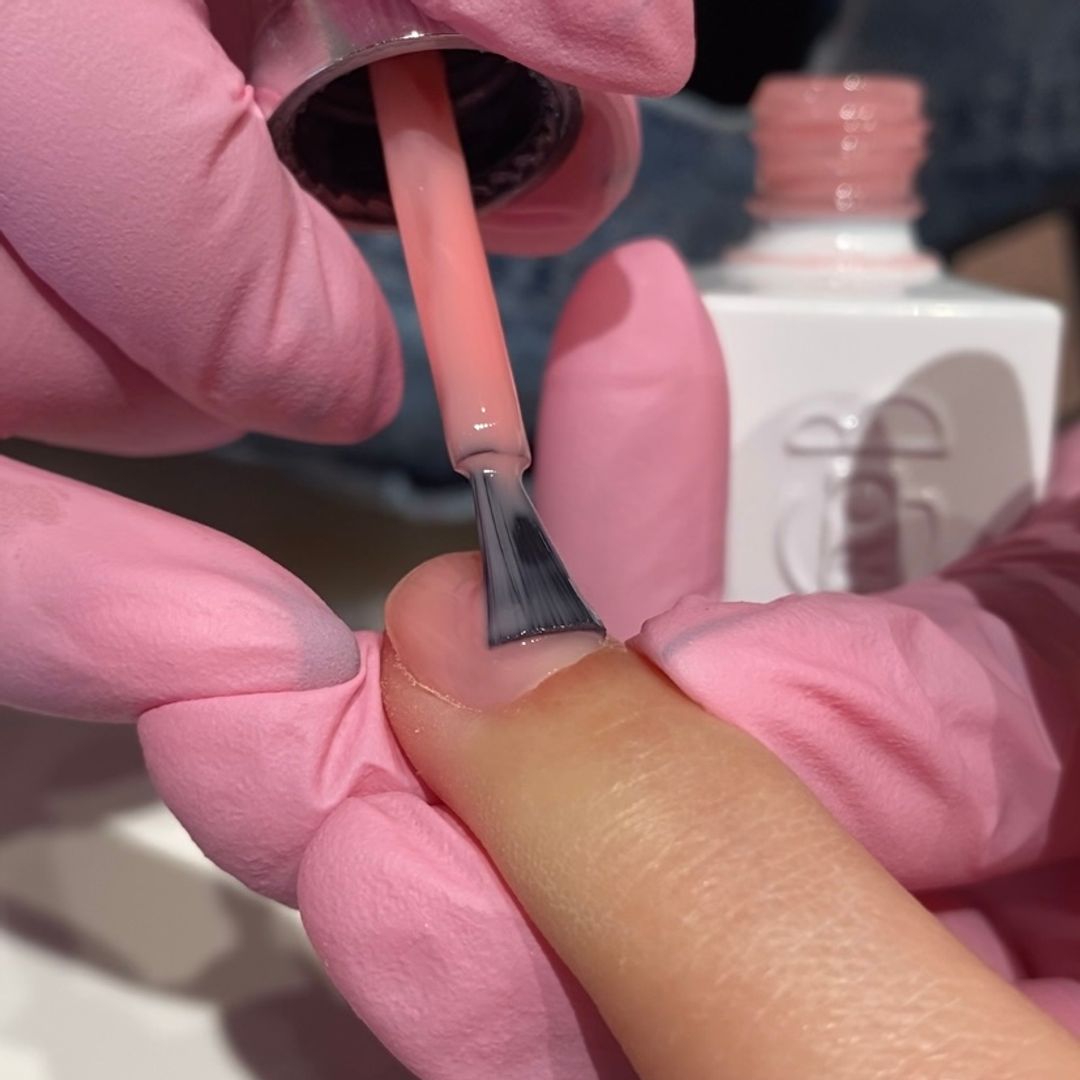 pink nail polish applied to fingernail