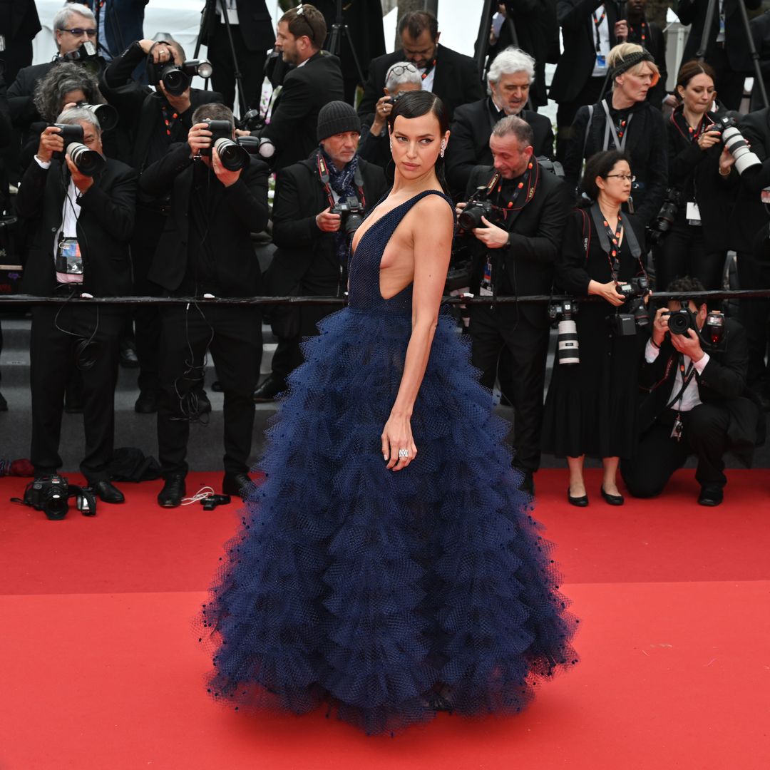 Irina on a red carpet in a long blue dress