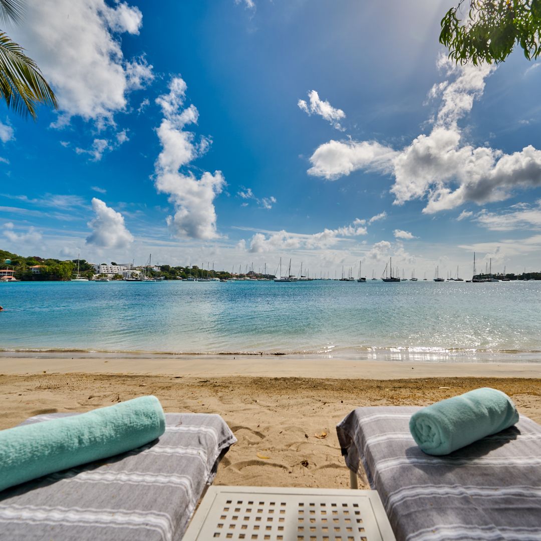 Beach front in Grenada with two sun loungers in the foreground
