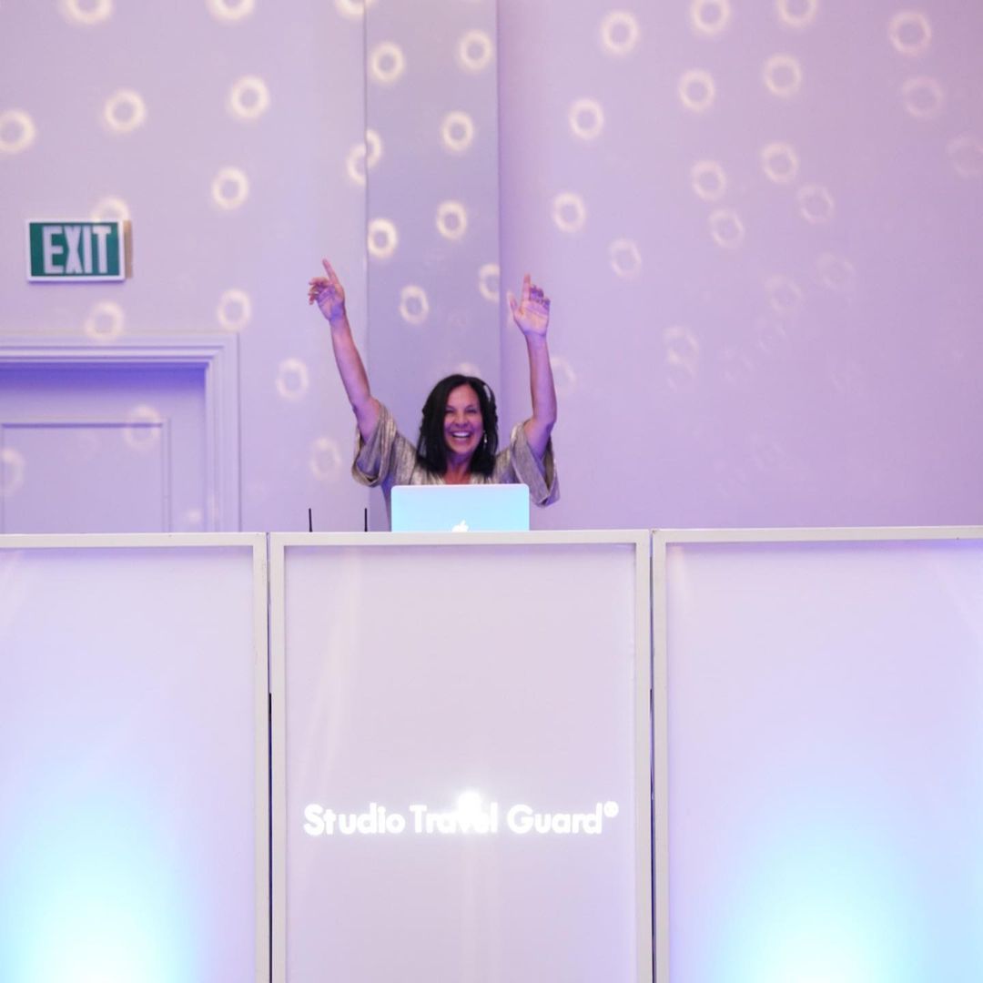 'Travel Mom' Emily Kaufman with her hands in the air enjoying her DJ set