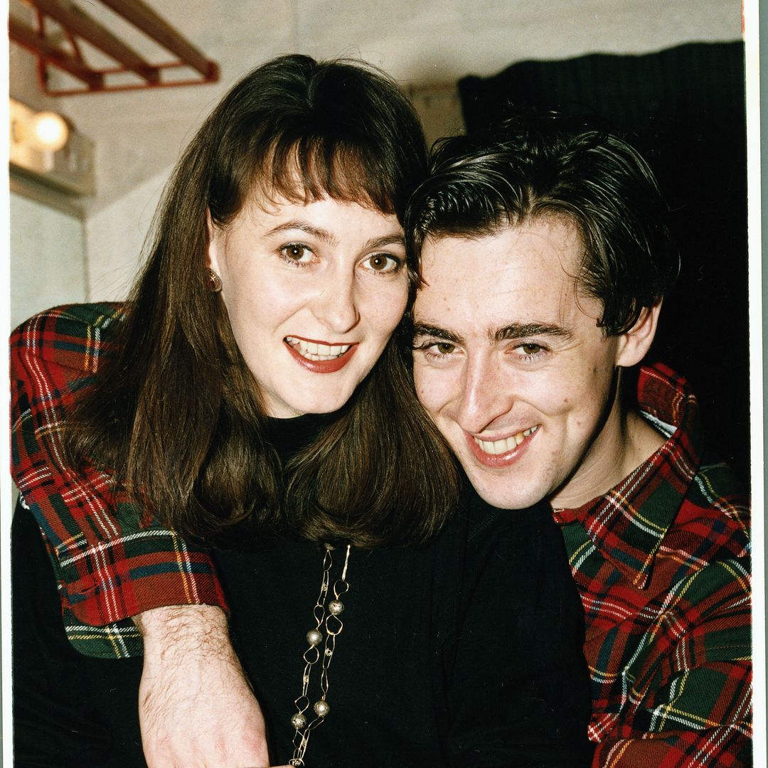 Alan Cumming with his arm around Hilary Lyon