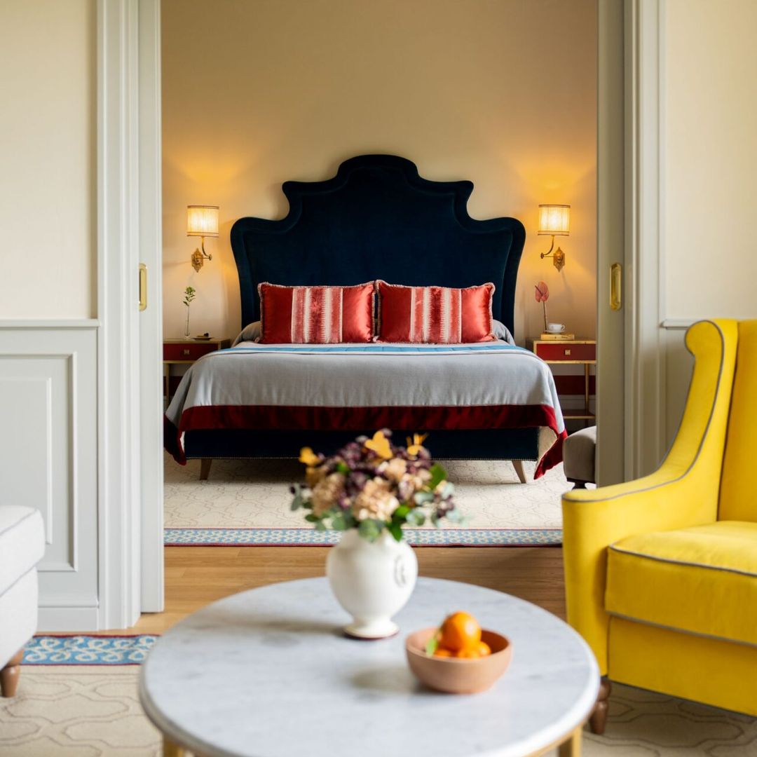 hotel room with bed in background of the shot and coffee table and armchair in foreground 