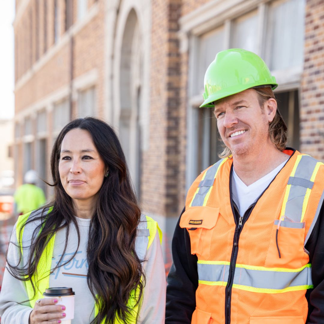  Joanna Gaines and Chip Gaines wear hard hats and high vis vests outside a property