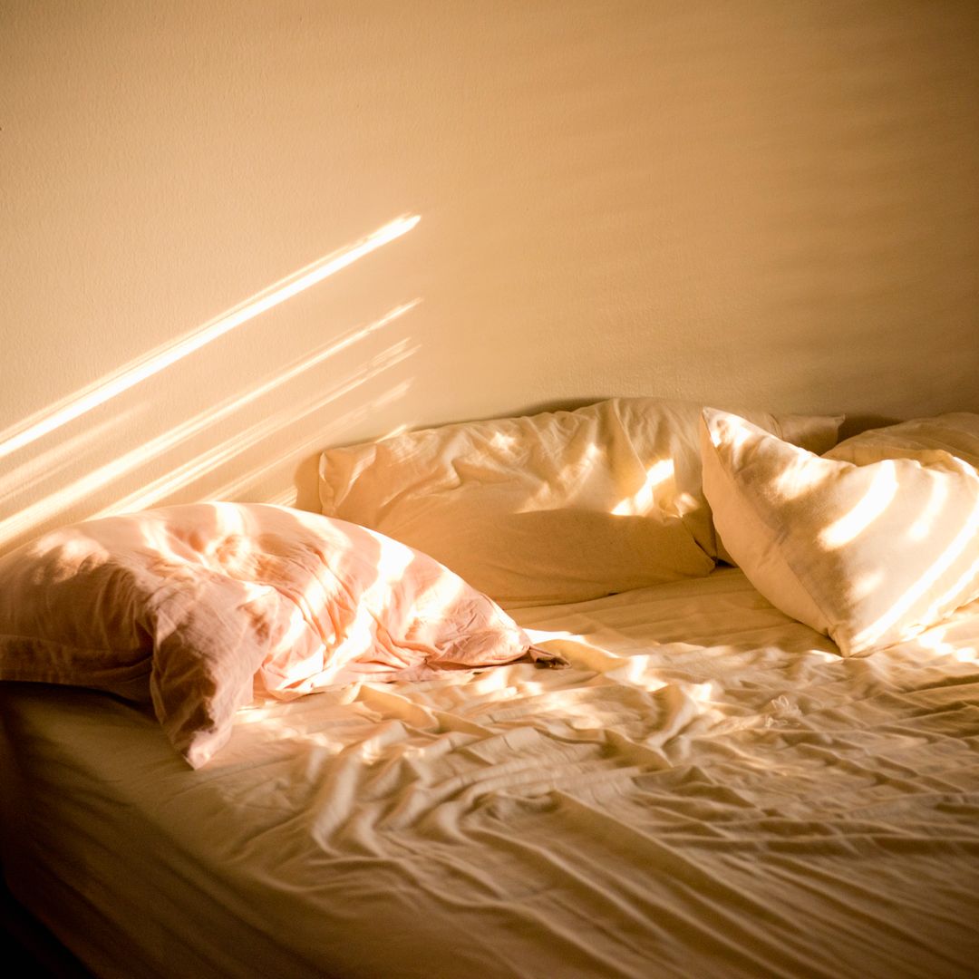 unmade bed in sunlight