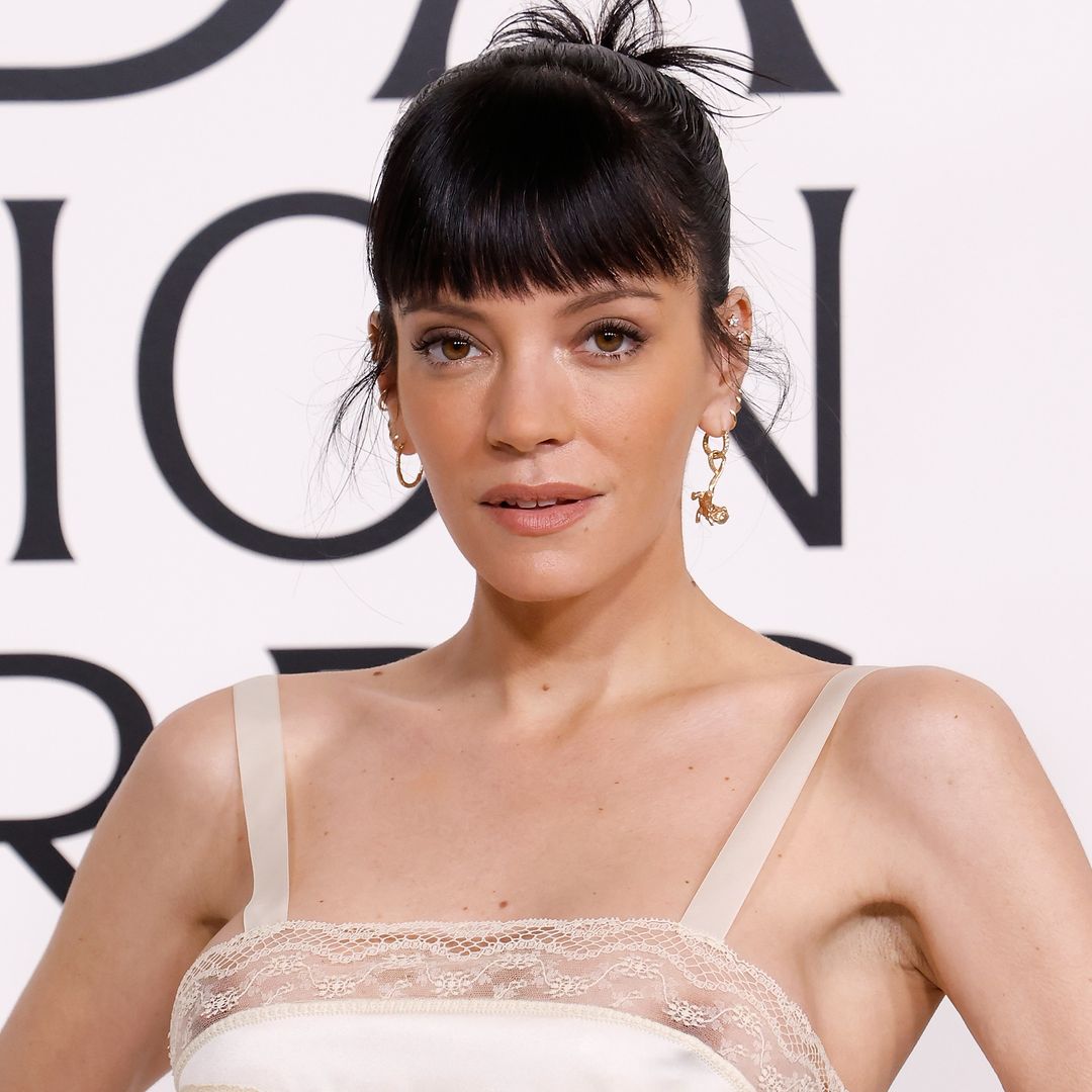 Lily Allen sports a strapless cut-out mini dress to perform onstage with Dakota Johnson