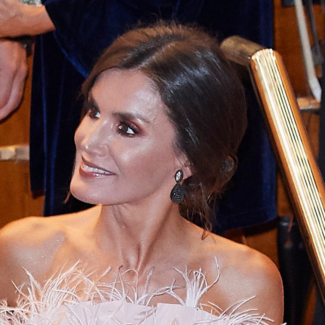 Pretty in pink! Queen Letizia rocks a feathered corset on a royal engagement with King Felipe