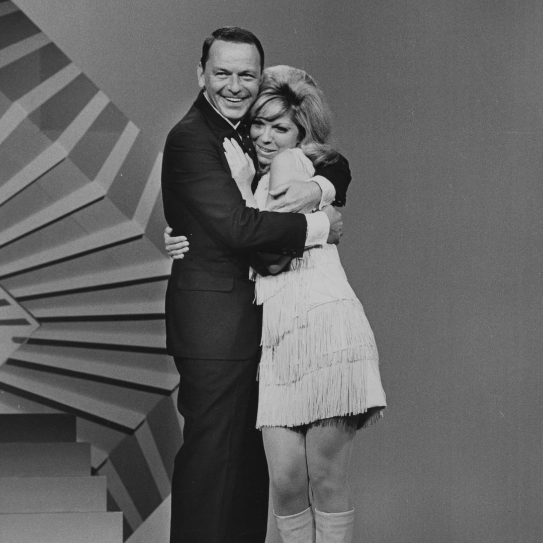 O cantor americano Frank Sinatra e sua filha, a cantora Nancy Sinatra, se abraçam no palco durante 'Frank Sinatra: A man and his music part II' por volta de 1966.