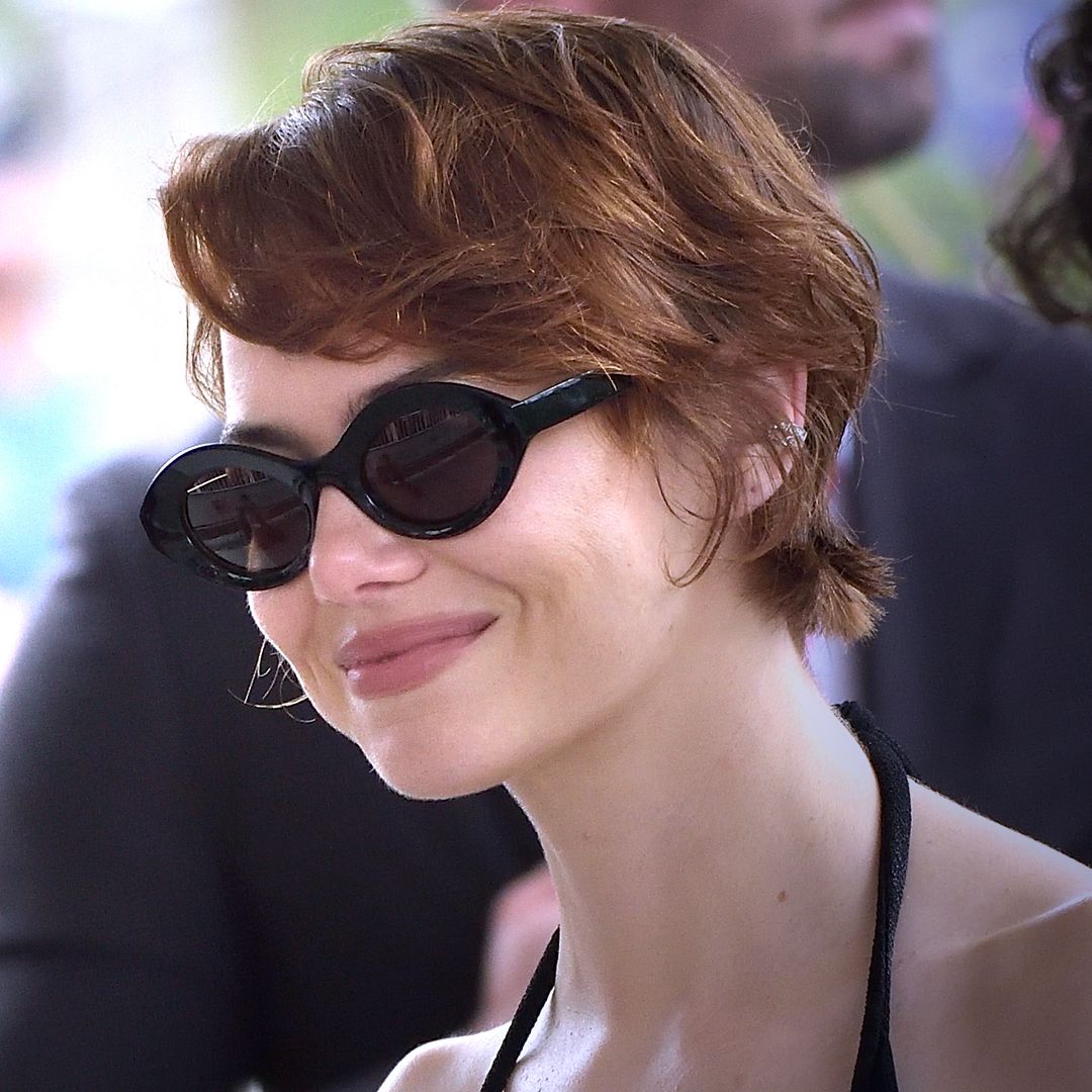 Emma stone's choppy pixie cut wearing a black dress and shades