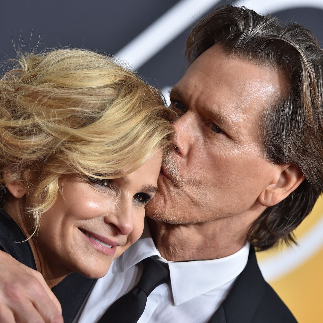 Kevin Bacon kissing Kyra Sedgwick on the forehead on a red carpet
