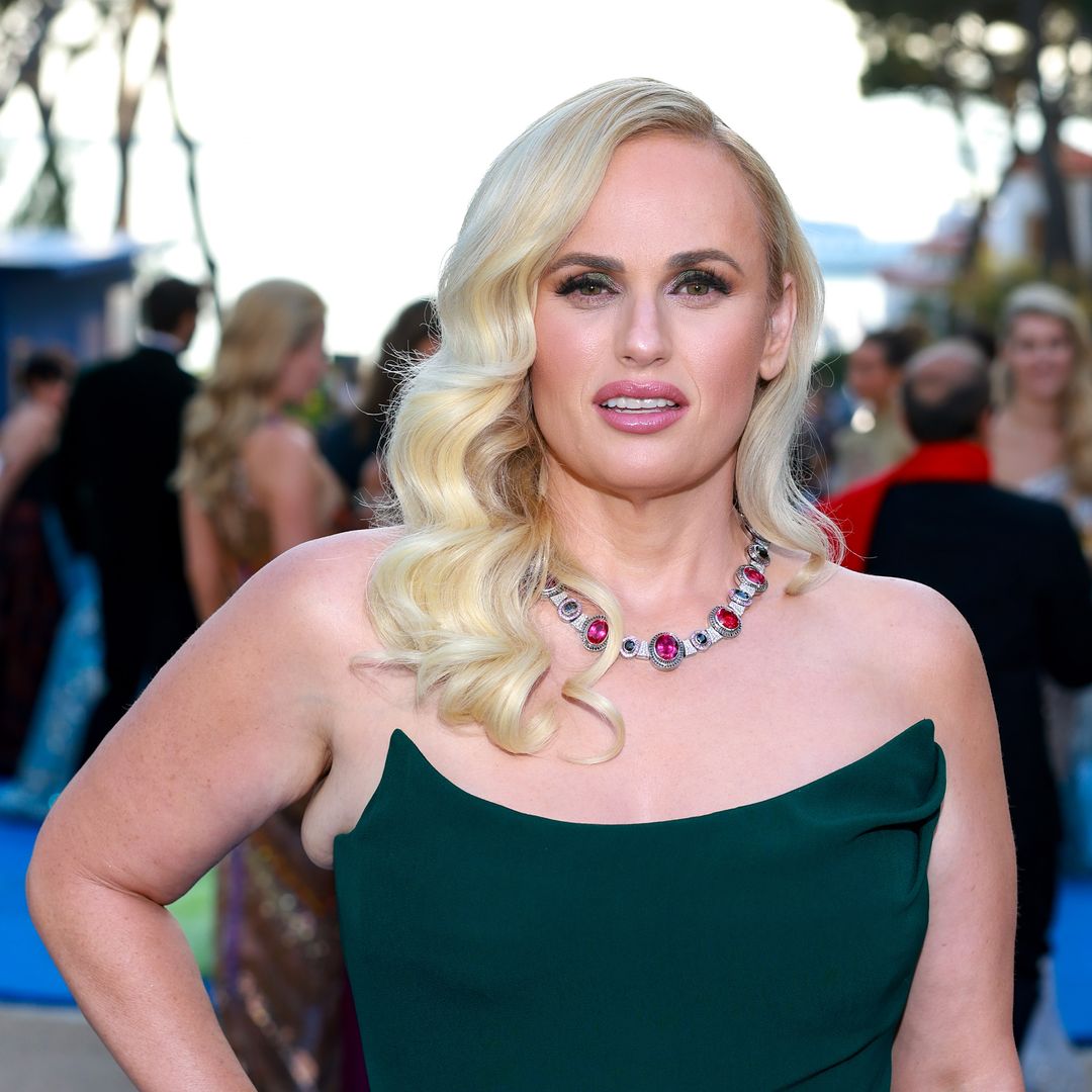 Rebel Wilson stuns in a plunging neon orange swimsuit in photo from romantic island vacation