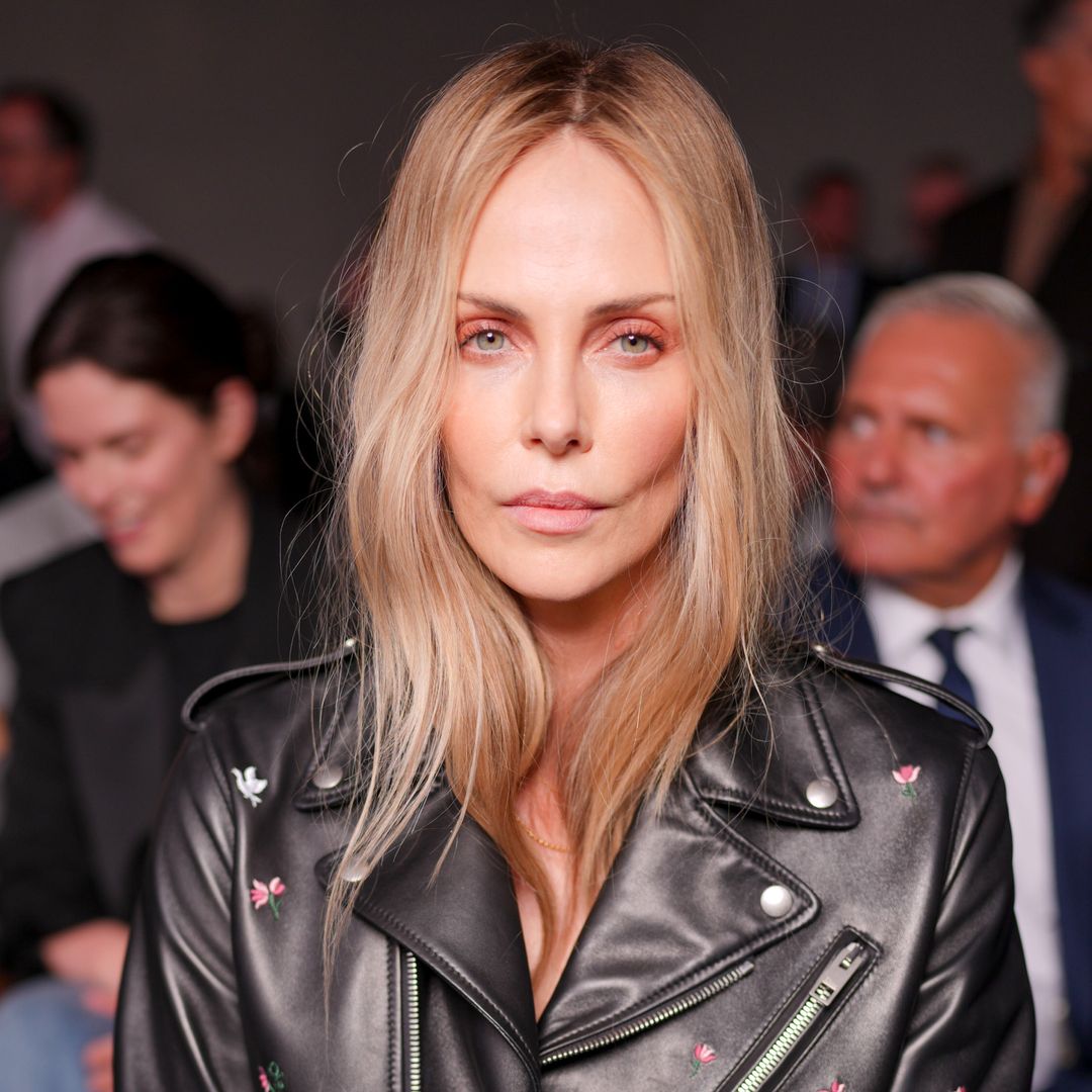 Charlize Theron opts for nothing under her biker jacket for bold fashion week appearance