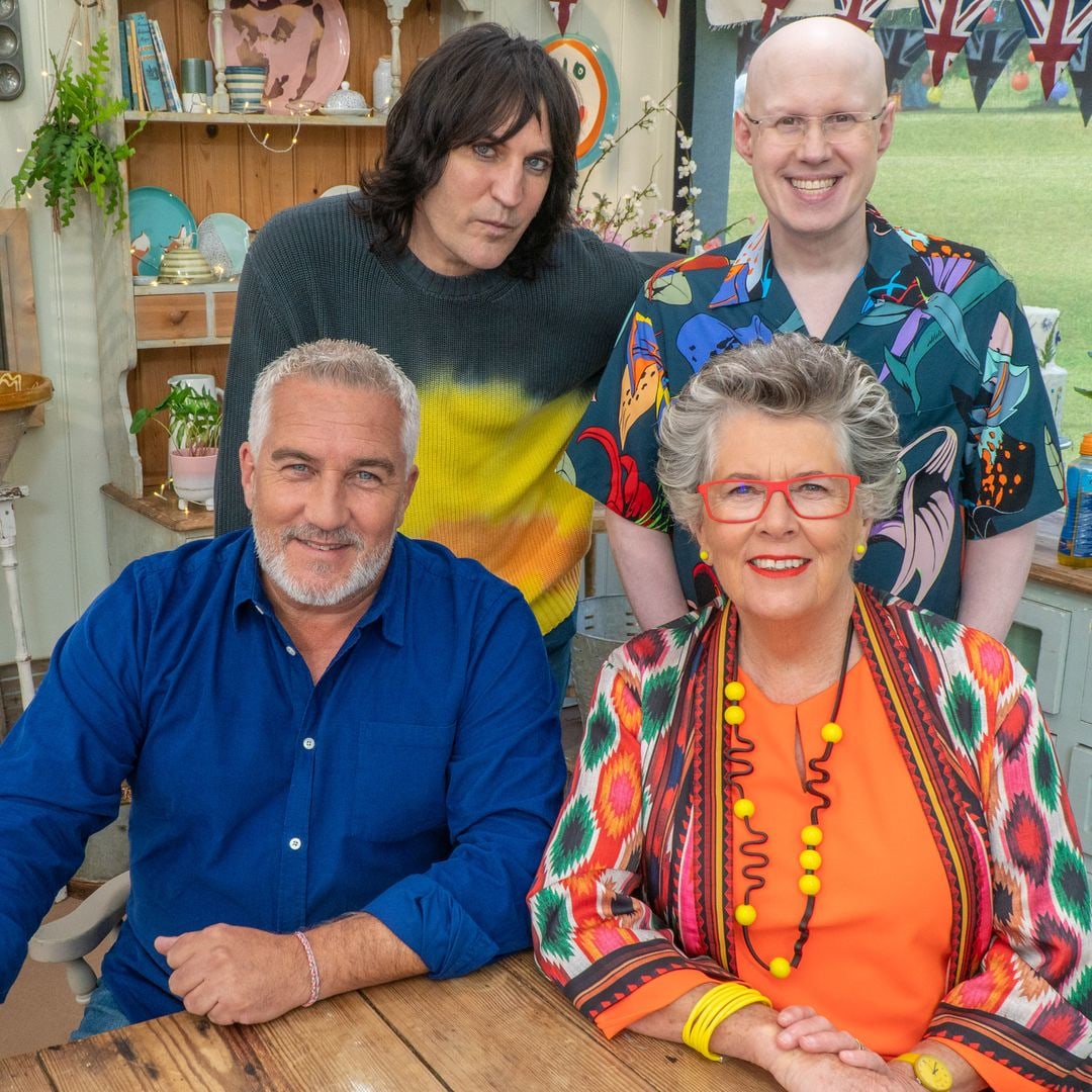 Matt Lucas smiling for a photo with Noel Fielding, Paul Hollywood and Prue Leith on The Great British Bake Off set