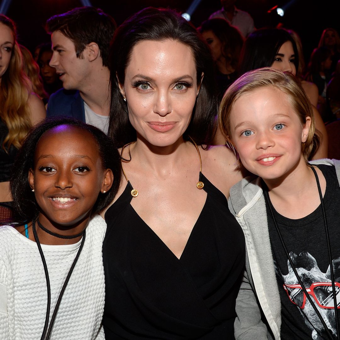 Angelina Jolie looking at the camera with her two young children on either side of her