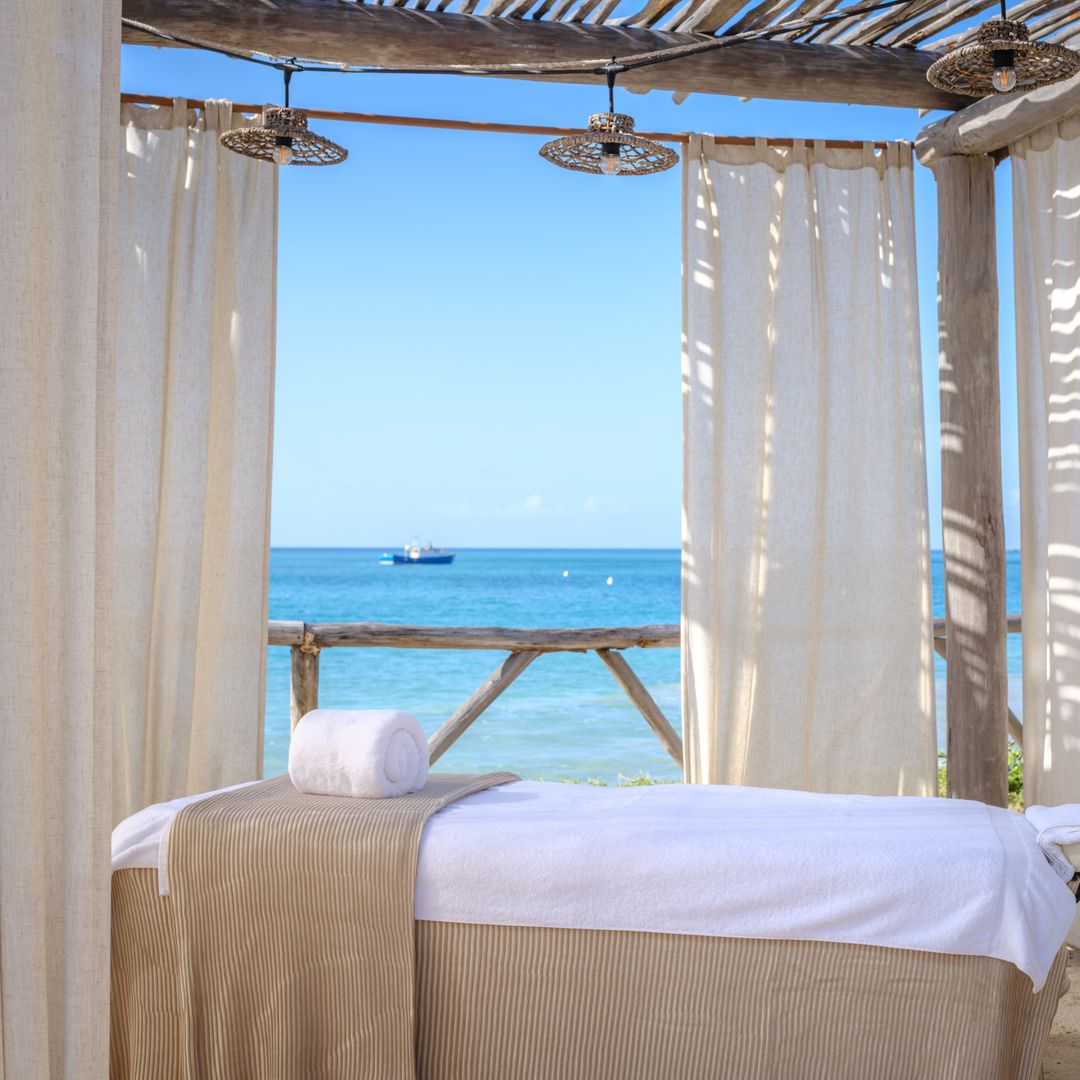 massage bed surrounded by drapes with ocean view in the background