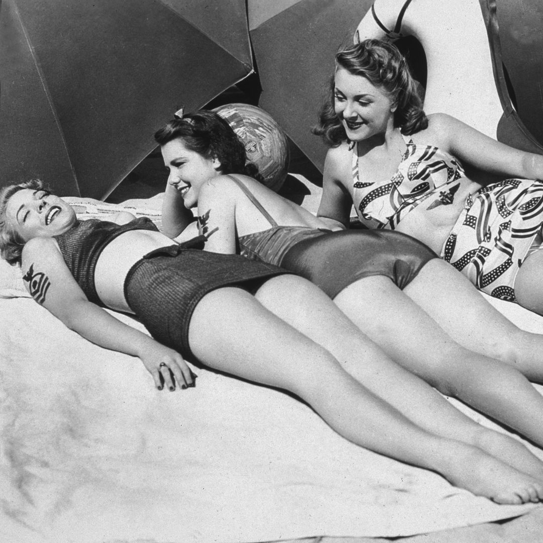 circa 1945:  L-R: American actors Anne Gwynne, Evelyn Ankers, and Helen Parrish lay in the sun, attempting to create 'sun tattoos' of military insignia on their bodies for their boyfriends in the U.S. Armed Forces. 