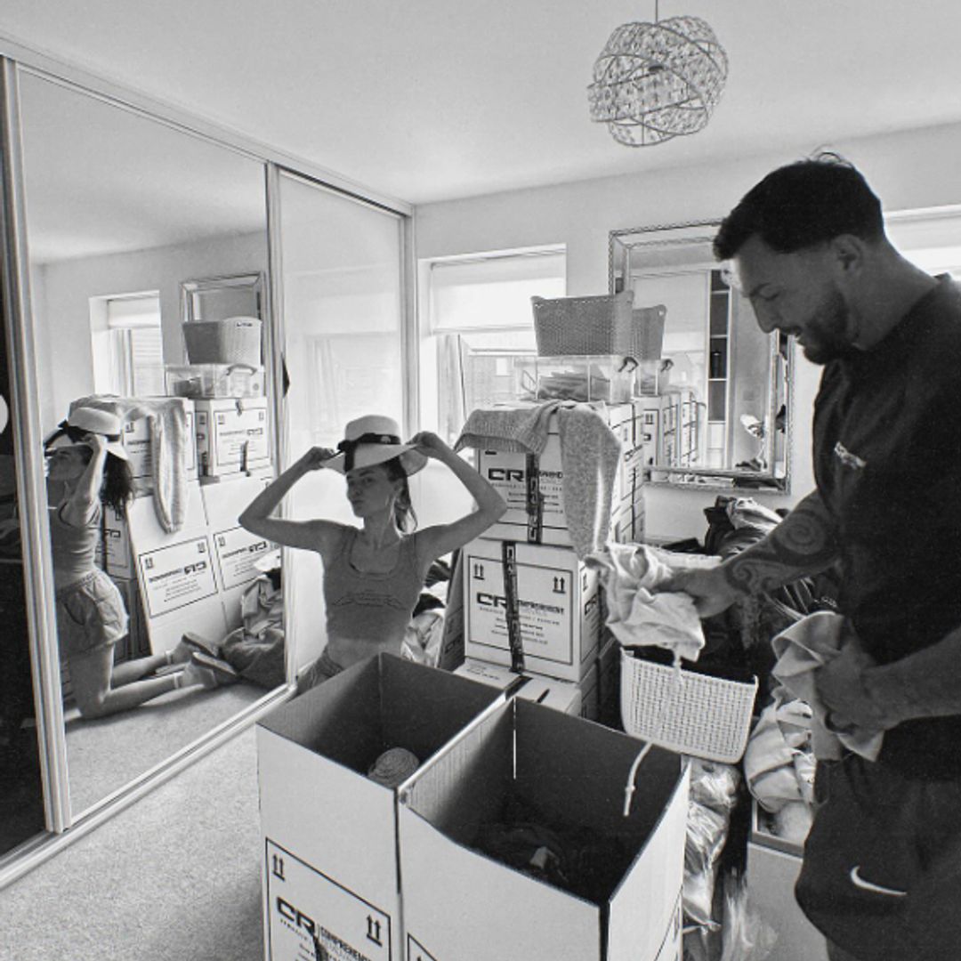 Black-and-white photo of Amber Davies and a man unpacking a bedroom