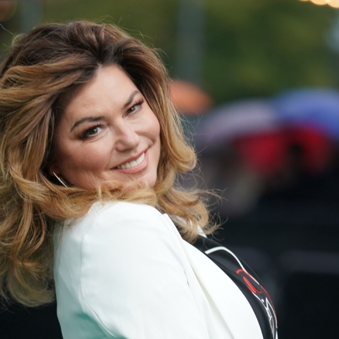 Shania Twain strikes a pose in leather coat and thigh-high boots