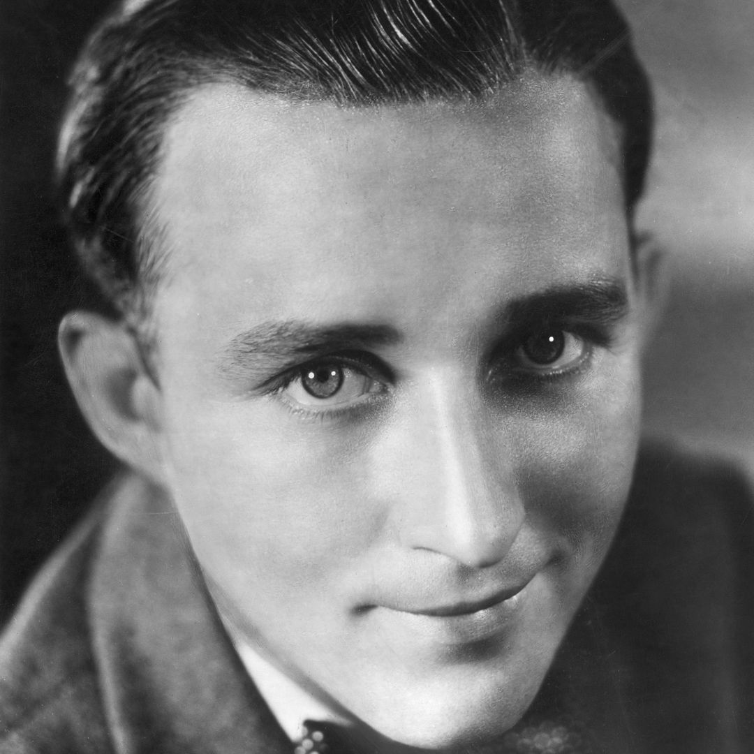 Closeup portrait of American singer and actor Bing Crosby smiling, wearing a jacket and a bow tie.