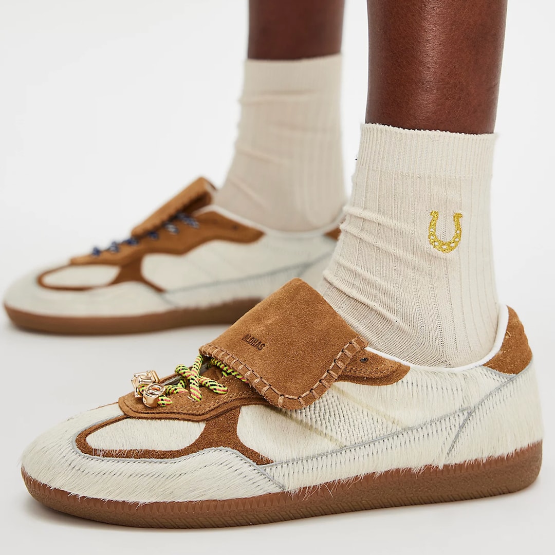 A close up of a model wearing a cream pair of Alohas Tb.490 Club Sneakers and a set of ribbed socks 