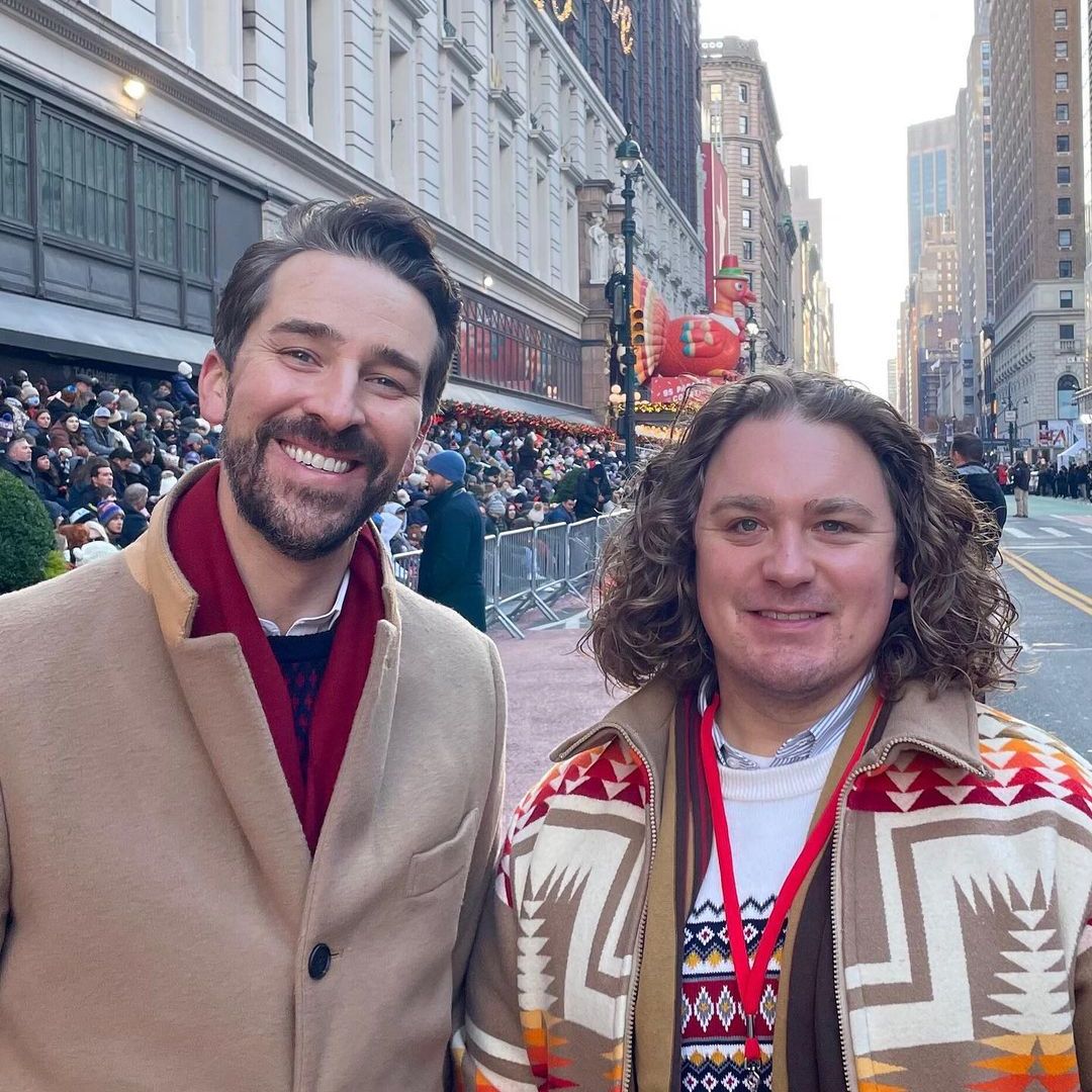 Joe with his partner Peter smiling at the thanksgiving day parade in 2021