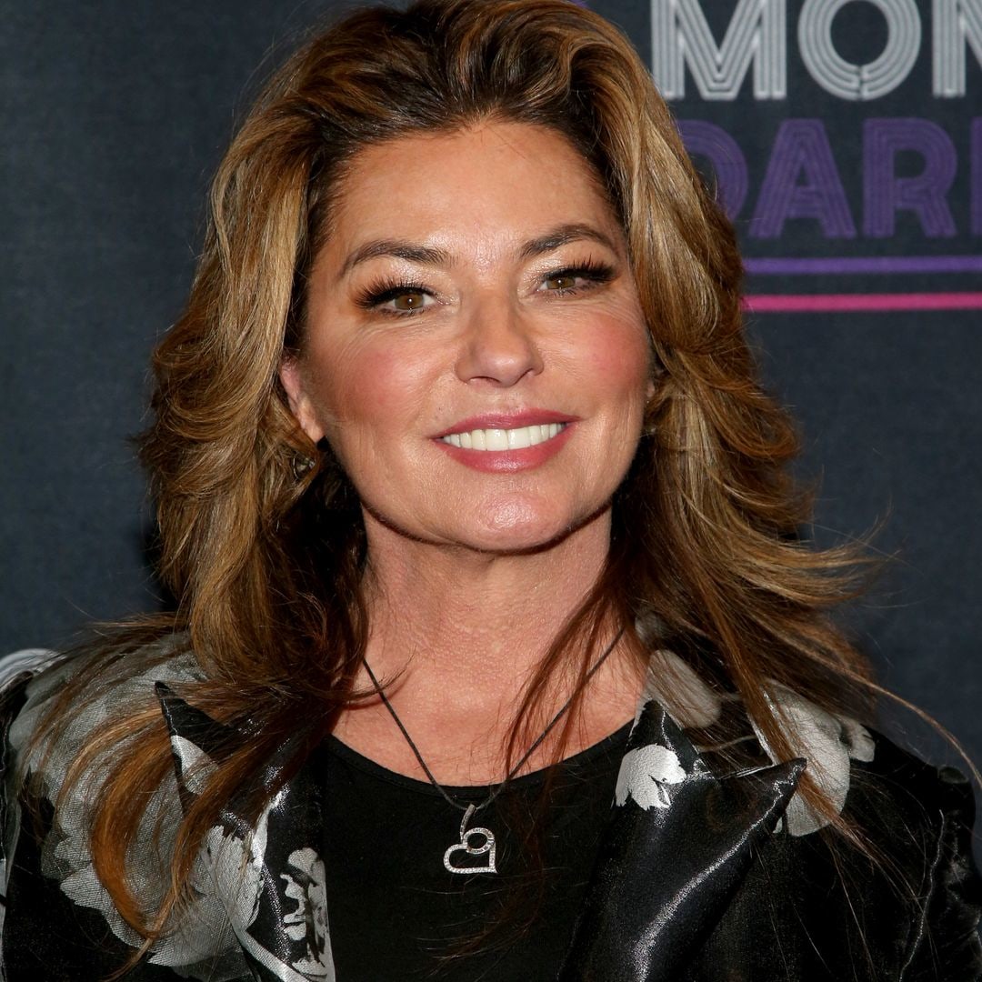 Shania Twain is a bombshell in tiny white mini skirt and sheer crop top with a twist