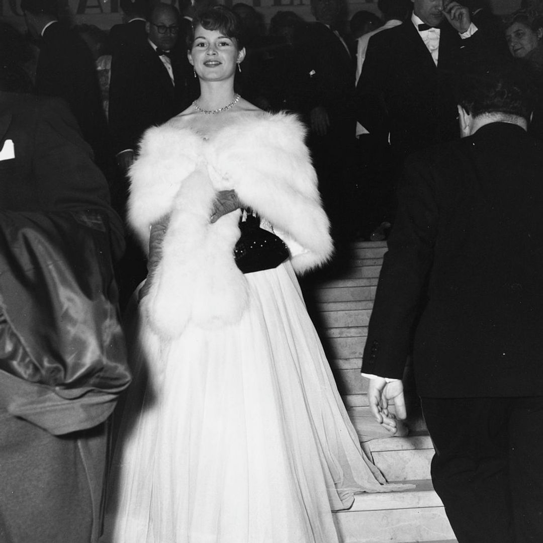 Brigitte Bardot wearing a ball gown and fur stole at the Cannes Film Festival 1953