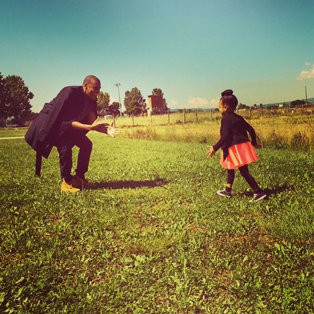 Jay-Z playing with his daughter Blue Ivy in a field