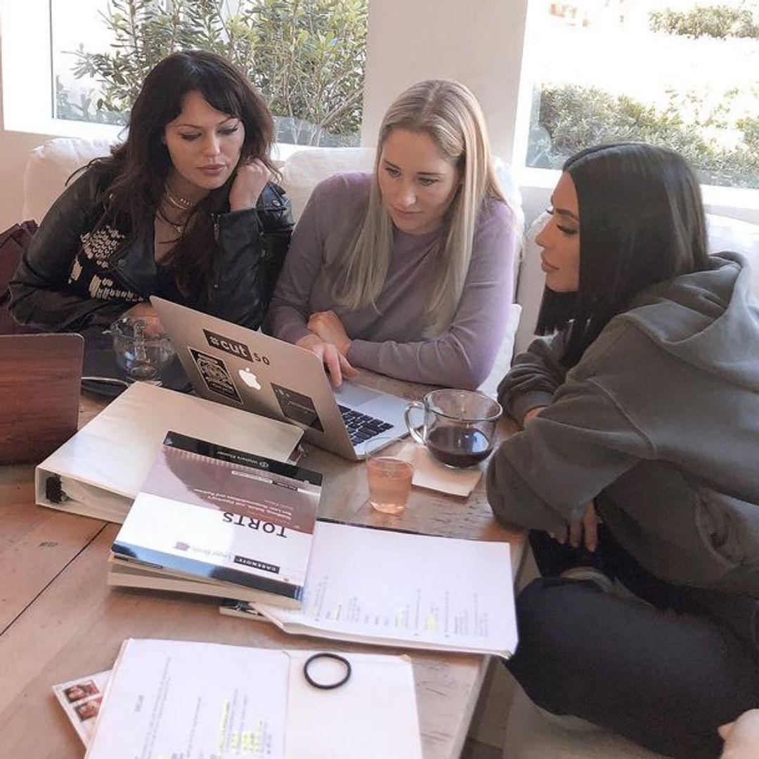 Kim studying with a macbook with attorneys Jessica Jackson and Erin Haney sat beside her