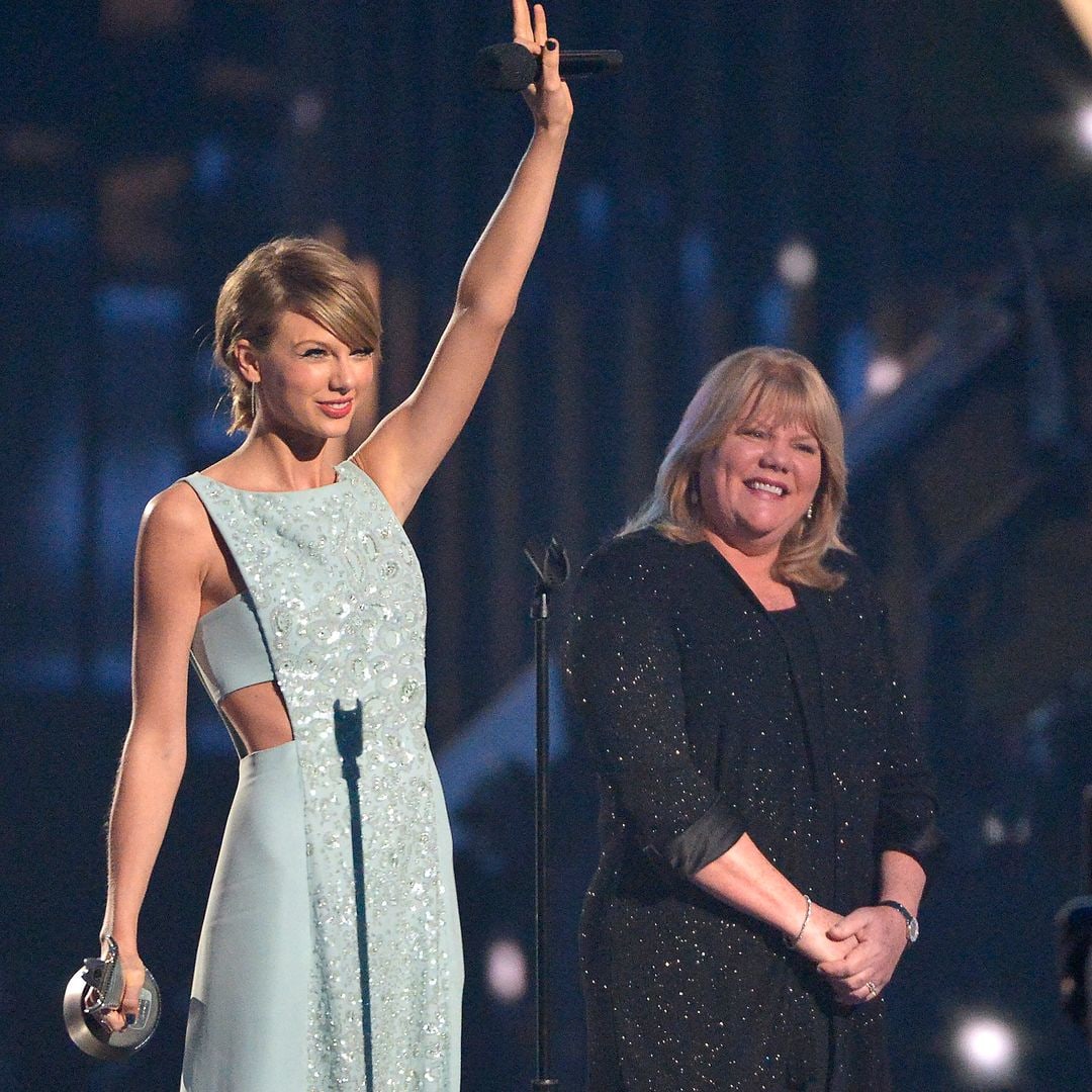 Taylor on stage celebrating with her mom beside her smiling proudly