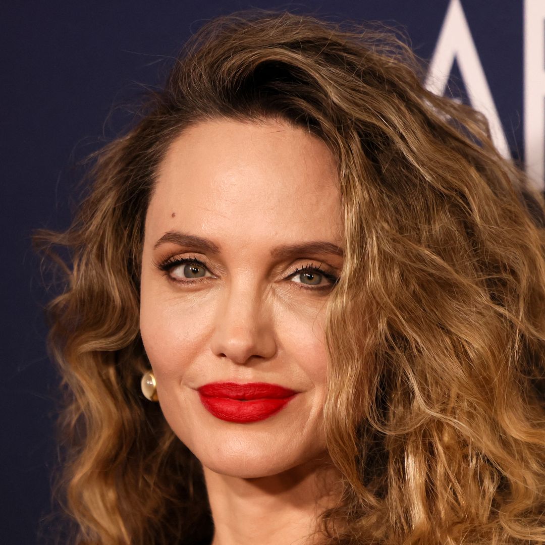 Angelina Jolie rocks figure-hugging liquid gold dress and tumbling curls