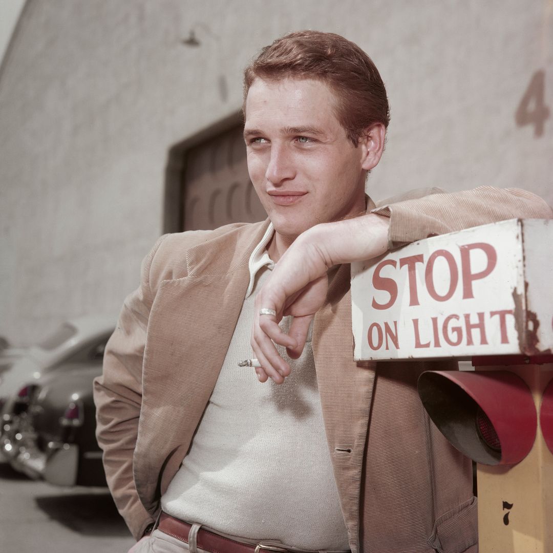 American actor Paul Newman (1925 - 2008) leaning on a sign which reads 'Stop on Light' at a film studio during the filming of 'The Silver Chalice', circa 1954.