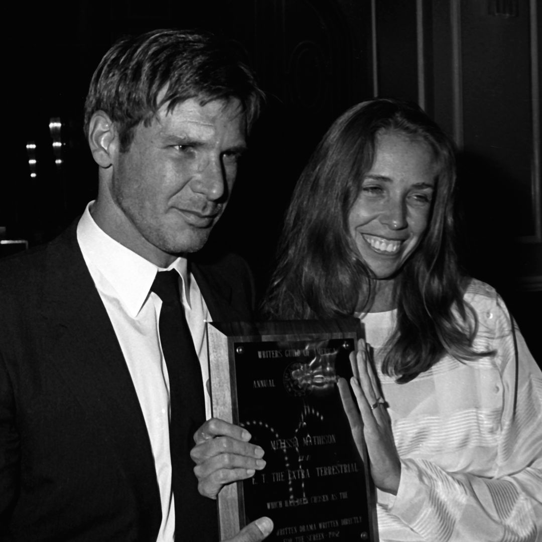 Black and white photo of Harrison Ford and Melissa Mathison smiling in a photo
