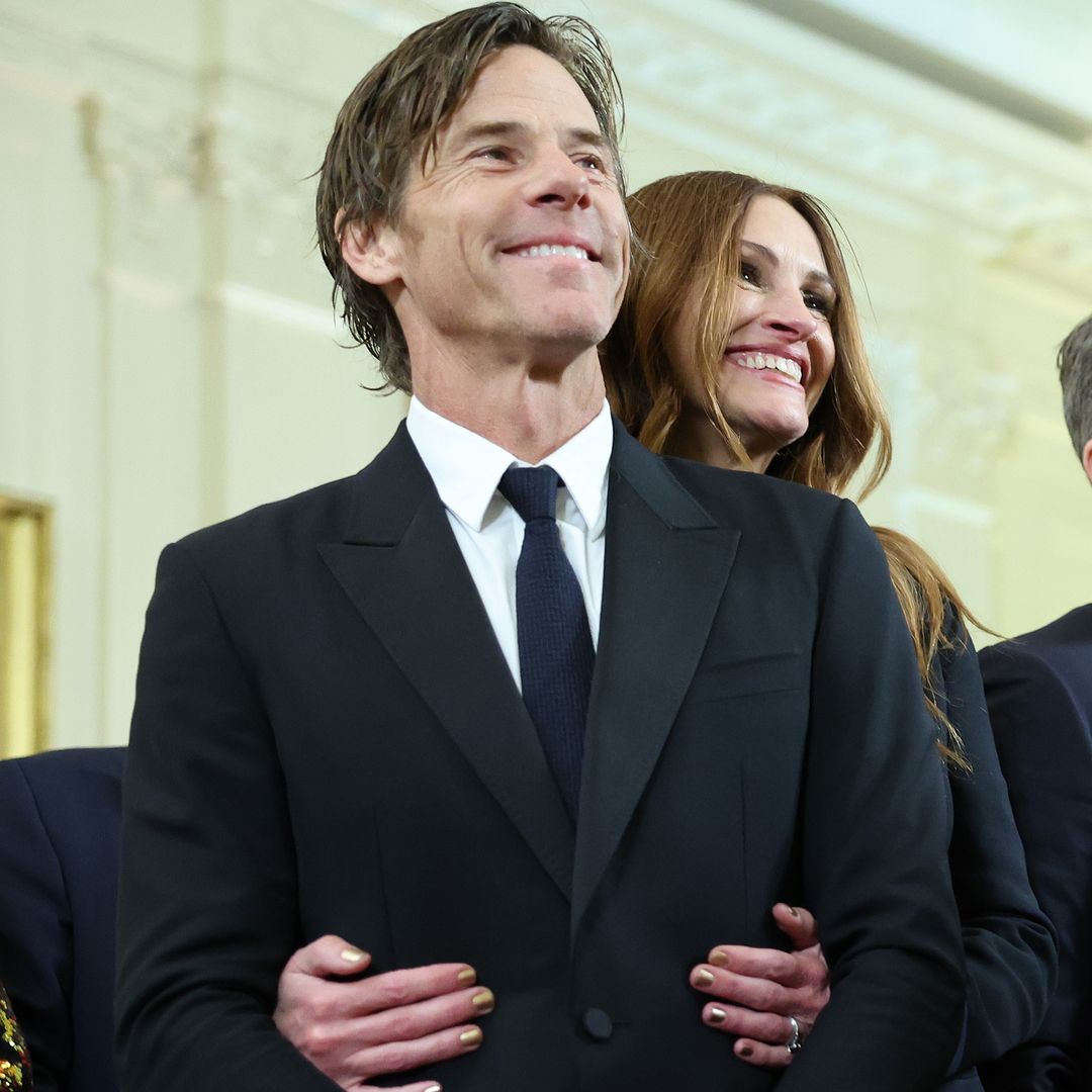 Julia Roberts smiling and hugging a smiling Daniel Moder from behind