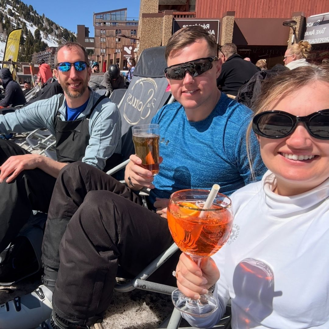 Skiers drinking Aperol Spritzes in the sunshine