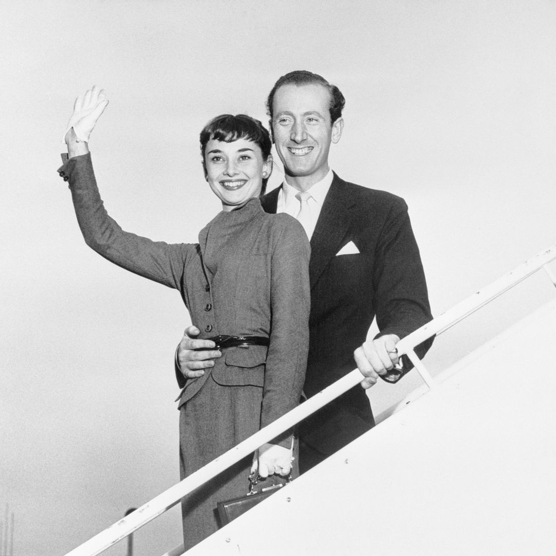 New York, NY- Film and stage actress Audrey Hepburn and her fiance James Hanson smile broadly upon their arrival from Rome at New York's Idlewild Airport. Their plans to be married in London were interrupted by Miss Hepburn's shooting schedule for a film in Rome and contract commitments in the U.S. They hope to wed as soon as schedules permit. A road company tour of the play "Gigi" will take Miss Hepburn to various parts of the country.