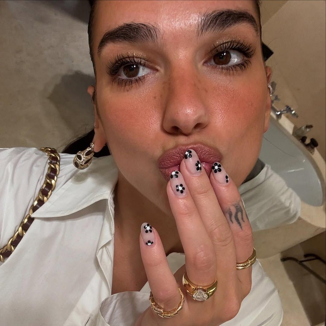 Dua Lipa pouting showing off her daisy manciure 