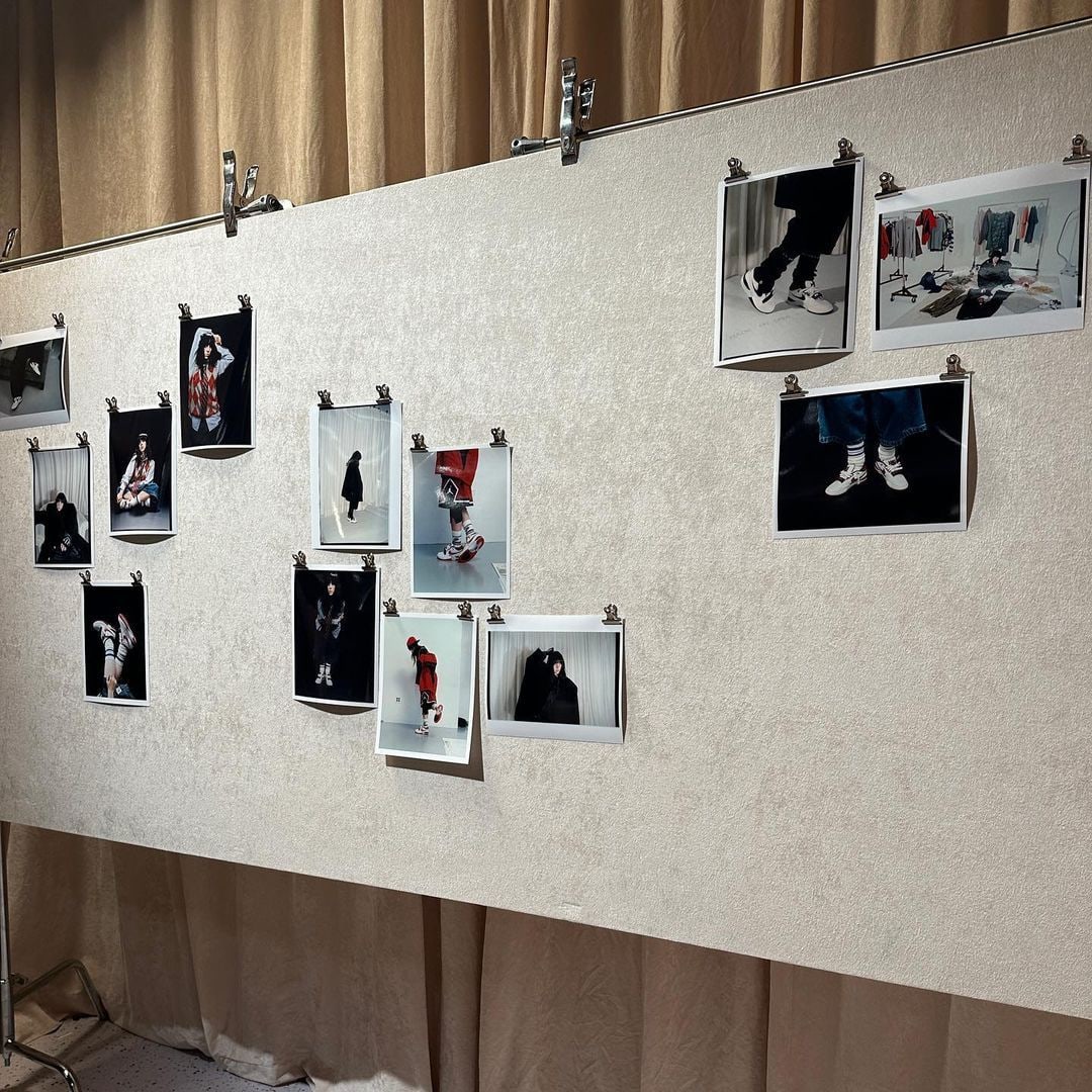 A board with several photos of models wearing shoes, shirts etc pinned to it