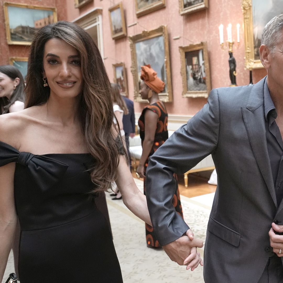 Another shot of Amal in her black midi dress and George in his grey suit